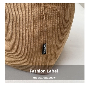 Gros plan du sac en velours côtelé marron montrant la texture et l'étiquette mode