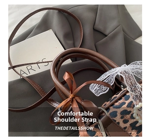 Detail of leopard print handbag with ribbon, lace bow and comfortable shoulder strap