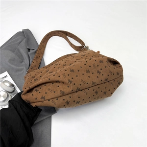 Brown corduroy tote bag with heart patterns and shoulder strap on white background
