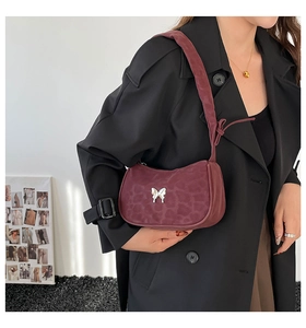 Close-up of wine red leopard print shoulder bag with silver butterfly buckle detail