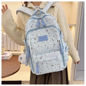 Detail of light blue backpack with star pattern and white cloud plush charm detail