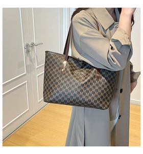 Detail of monogram M print tote bag with a golden bow buckle and leather straps