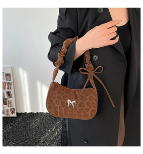 Detail of leopard print handbag with silver butterfly buckle and ruffles