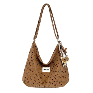 Brown corduroy tote bag with heart patterns and bear pendant on white background