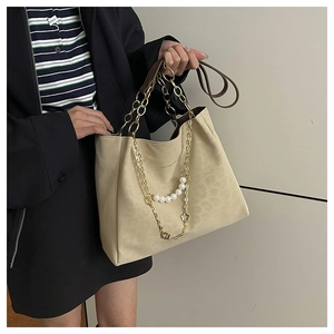 Close-up of beige leopard pattern tote with gold chains and pearl flower charms