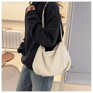 Detail of a large cream nylon tote bag styled for casual daily wear and commuting