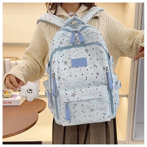 Close-up of light blue star print school backpack with cute plush cloud pendant detail