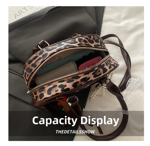 Detailed interior of leopard print crossbody bag showing storage capacity and zippered pockets