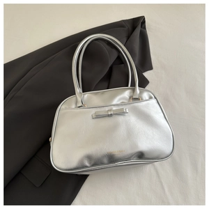 Dettaglio borsa a tracolla argento metallizzato con fiocco e logo moda minimalista