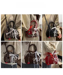Detail view showing variety of leopard print and solid color mini crossbody bags with charms
