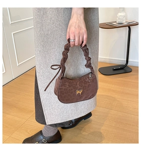 Close-up of brown leopard print PU bag with gold butterfly metal charm and ruched handle