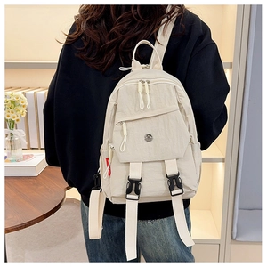 Detail of a mini off-white nylon backpack featuring a black buckle flap and long straps