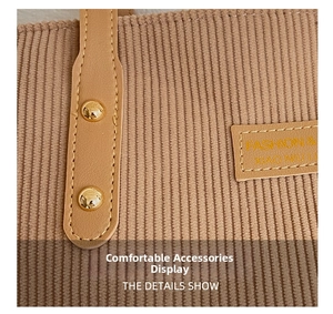 Detail of khaki corduroy tote showing leather handle, metal rivets, and embossed tag