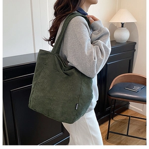 Gros plan détaillé du sac cabas en velours côtelé vert foncé avec texture nervurée