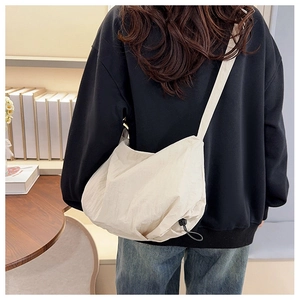 Detail of off-white nylon tote bag showing adjustable drawstring and pleated texture fabric