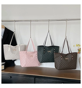 Detail view of large tote bags in four colors with M-letter pattern and gold bow charm