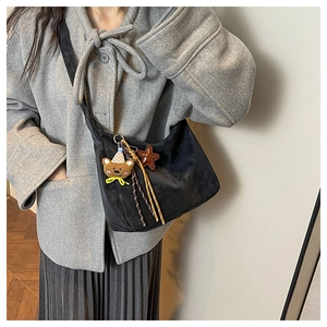 Detail of black crescent hobo bag with cute bear and star charms on adjustable strap
