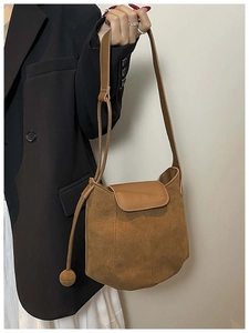 Détail du sac seau marron en daim avec cordon à perle ronde et bandoulière réglable