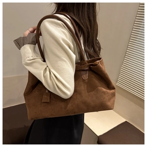 Detail of dark brown faux suede tote bag featuring a large capacity and long shoulder strap