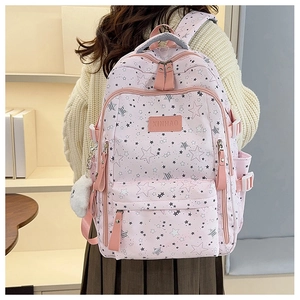 Rear view of pink school backpack with star patterns and plush charm on a student