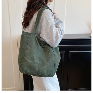 Détail du sac fourre-tout en velours côtelé vert foncé avec tissu texturé et étiquette