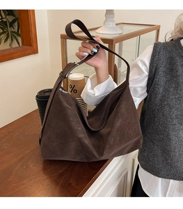 Dettaglio della borsa hobo in pelle opaca marrone scuro con tracolla regolabile