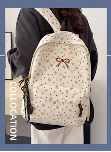 Detail eines cremefarbenen Cord Rucksacks mit Herzmuster und brauner Schleifenstickerei