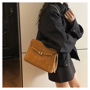 Detail view of brown suede tote bag featuring premium matte texture and gold swivel clasp