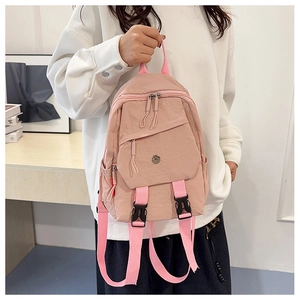 Pink multi-functional backpack detail showing fabric texture and round metal logo
