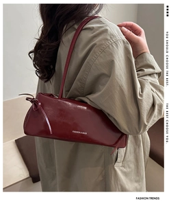 Dettaglio della borsa sottobraccio in pelle lucida bordeaux con nastro e logo moda