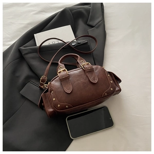 Detail of vintage brown leather handbag with metallic studs and side pocket design