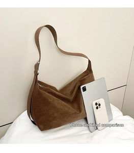 Borsa hobo marrone in pelle scamosciata accanto a iPad e telefono per la capacità