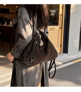 Macro shot of large vintage brown hobo bag showing matte leather texture and metal zipper