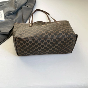 Classic dark brown tote bag with all-over M pattern and leather handles for office