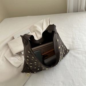 Dark brown faux leather tote bag with gold studs and spacious interior shown on a flat lay