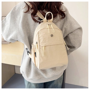Detail view of the beige multi-purpose backpack with adjustable straps and zip pockets