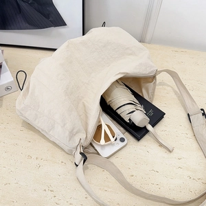 Large beige nylon tote bag with adjustable strap and spacious interior for daily use