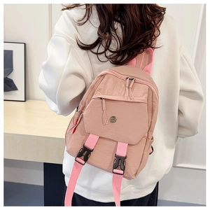 Detail of pink waterproof nylon backpack with secure buckle and round metal logo
