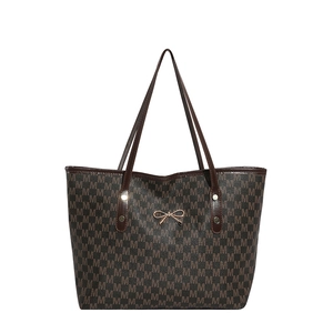 Brown monogram tote bag with gold bow accent and long shoulder straps on white background