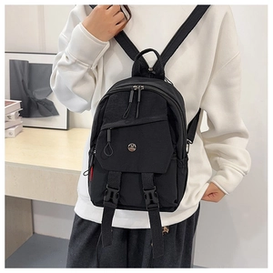 Close-up of black waterproof mini backpack with metal M logo and buckle detail