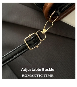 Detail of adjustable black patent leather strap with gold buckle on tote bag