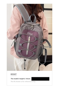 Grand sac à dos de voyage gris et violet avec cordon élastique sur un mannequin de 165 cm