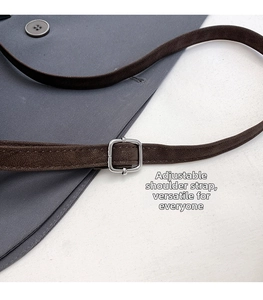Detail view of the adjustable dark brown leather shoulder strap with silver buckle
