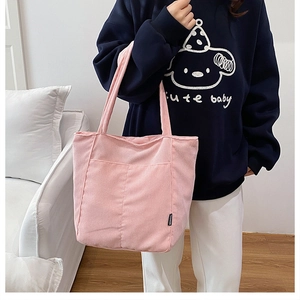 Détail du sac cabas en velours côtelé rose avec texture côtelée et étiquette de mode