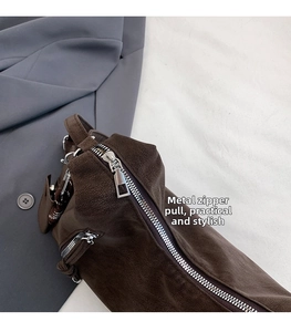Detailed macro view of high-quality silver metal zipper on brown suede bucket bag