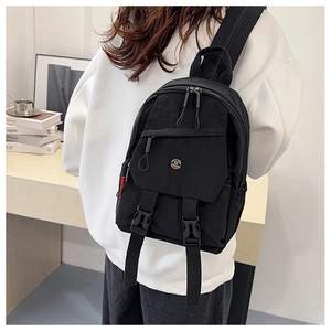Detail of waterproof nylon sling bag with metal M logo and adjustable buckle straps