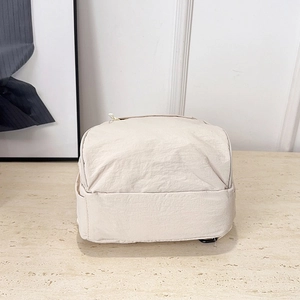 Versatile beige nylon multi-way backpack for women on light marble background surface
