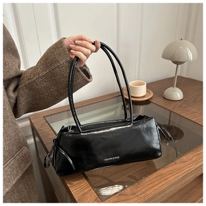 Dettaglio della borsa sottobraccio nera lucida con scritta Fashion & Bags