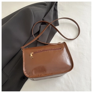 Rear view of brown faux leather shoulder bag featuring functional gold zipper pocket