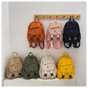 Multiple colorful waterproof nylon backpacks displayed on racks and a white platform